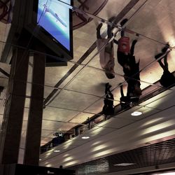 Low angle view of men on cable against sky