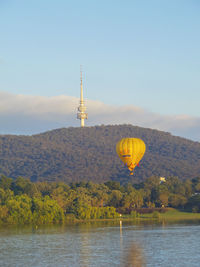 Hot air balloon flying over water against sky