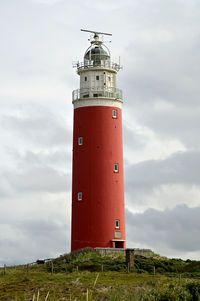 Lighthouse by sea against sky