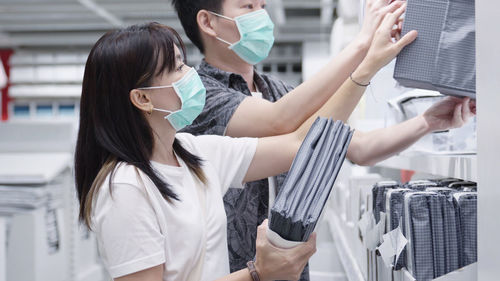 New normal after covid epidemic young couple asia choose bedsheet in supermarket