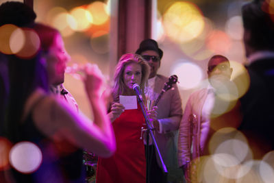 People celebrating and having fun on a party, woman making an announcement