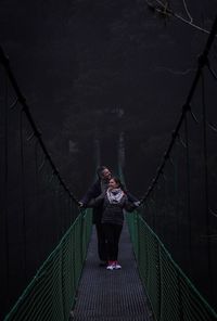 Couple standing on footbridge 