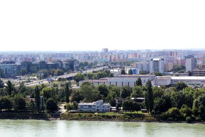 River by buildings against clear sky