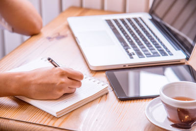 Close-up of woman using laptop on table