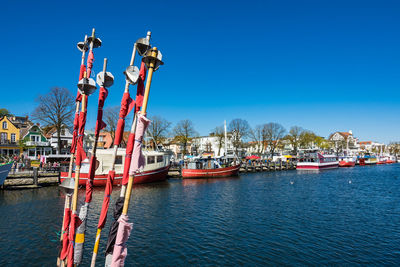 Ship moored at harbor against clear blue sky