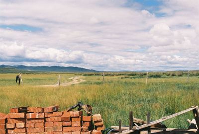 Scenic view of field against cloudy sky