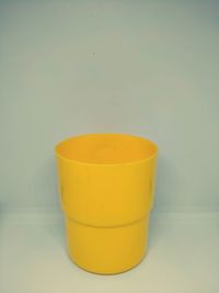 Close-up of yellow cup over white background