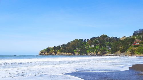 Scenic view of beach against clear blue sky