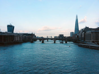 View of buildings and bridge in city against sky