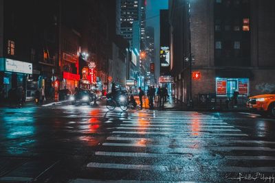 Illuminated city street during rainy season at night