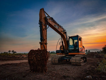 Construction site on field against sky during sunset