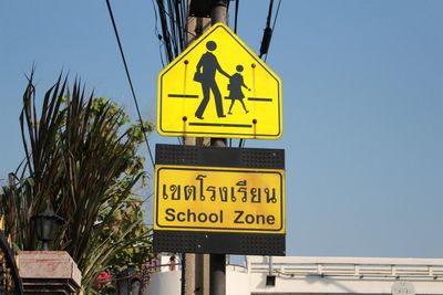 Low angle view of information sign against clear blue sky