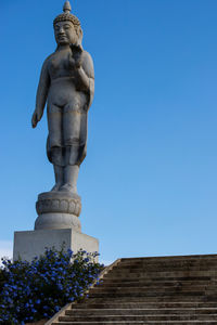 Low angle view of statue against blue sky