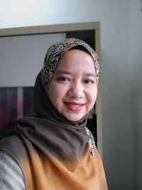 Portrait of smiling young woman wearing eyeglasses at home