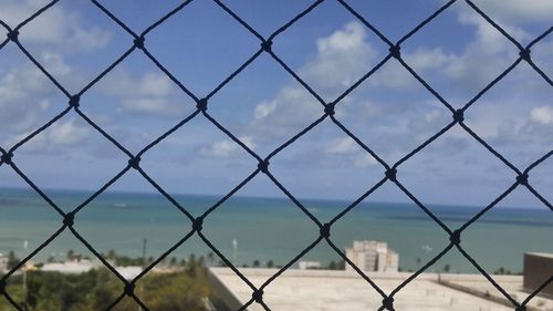 Full frame shot of chainlink fence against sky