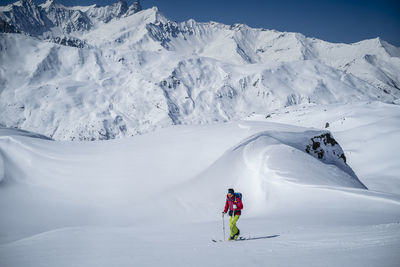 Man skiing on snowcapped mountains during winter