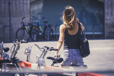 Woman with bicycle on street in city