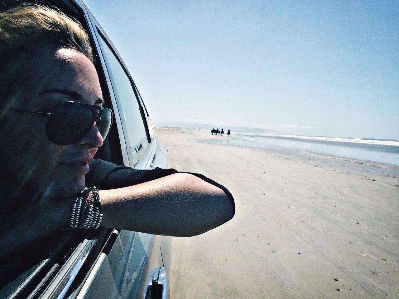 sea, beach, clear sky, horizon over water, sand, transportation, mode of transport, leisure activity, lifestyles, shore, water, copy space, land vehicle, sunlight, travel, men, sky, incidental people