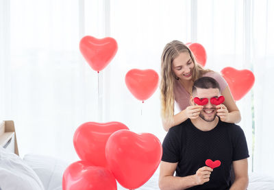 Woman holding heart shaped balloons