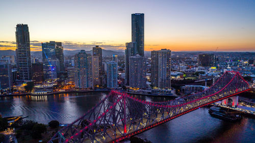 Aerial view of buildings in city at sunset