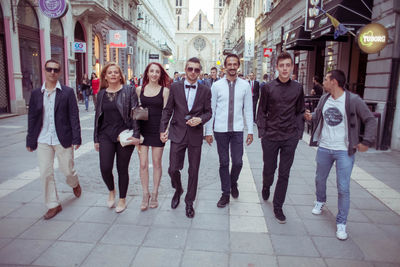 Full length portrait of friends standing in city
