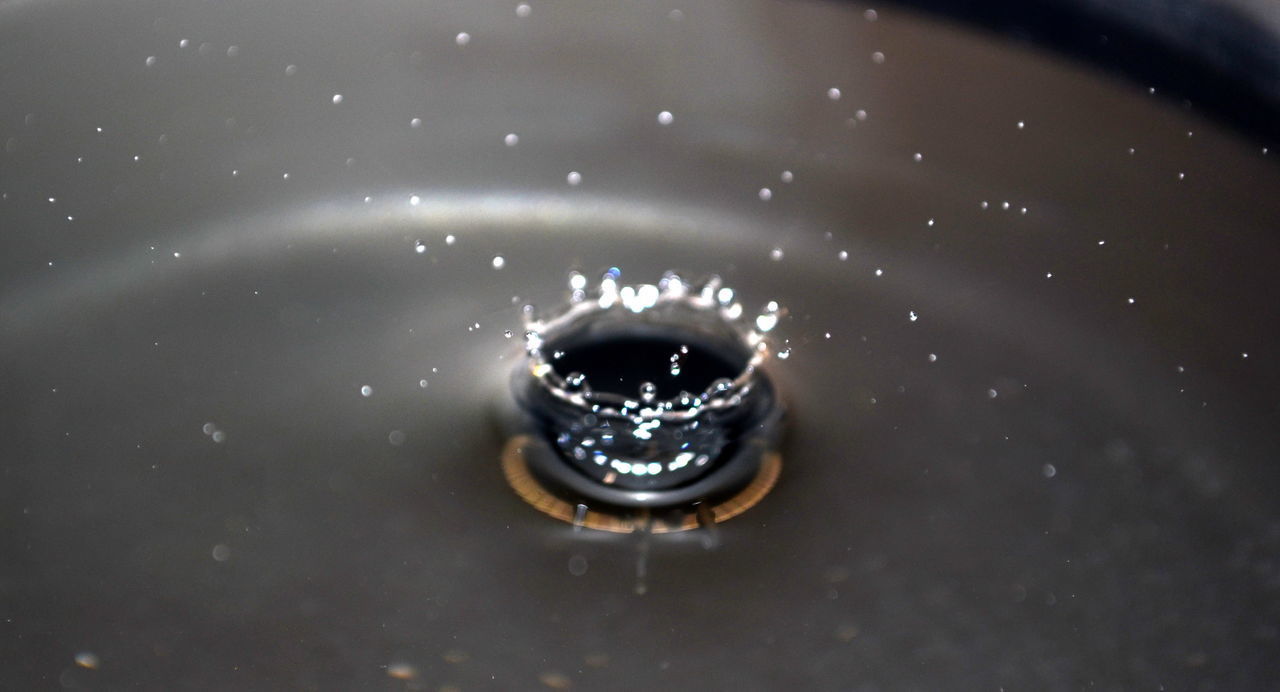 HIGH ANGLE VIEW OF WATER DROP ON METAL