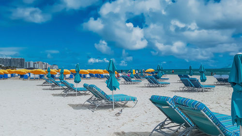 Chairs on beach against sky