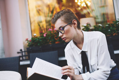 Side view of man using laptop while sitting on table