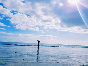 Distant view of father holding daughter at beach