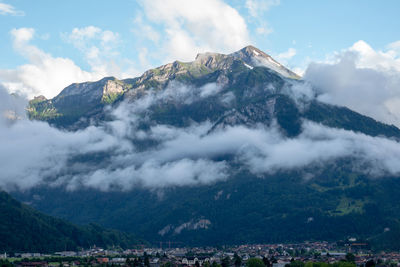 Scenic view of snowcapped mountains against cloudy sky