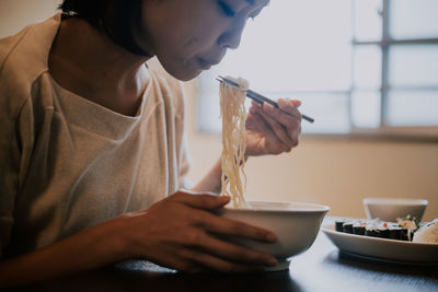 Beautiful woman eating food sitting at home