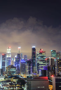 Illuminated buildings in city against sky at night