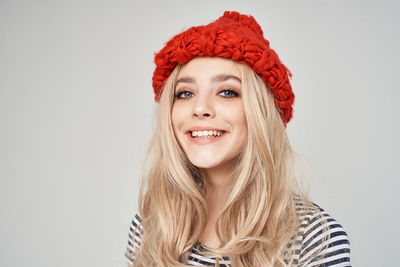 Portrait of smiling young woman against white background