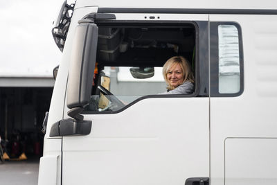 Caucasian mid age woman driving truck. trucker female worker, transport industry occupation