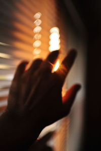 Close-up of hand on illuminated lamp