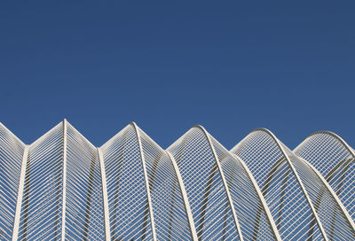 Low angle view of modern building against clear blue sky