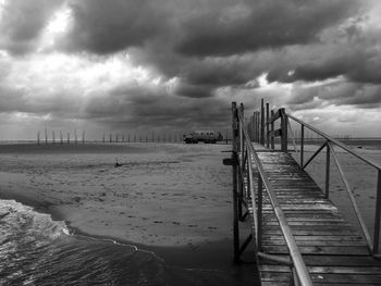 Pier on beach against sky