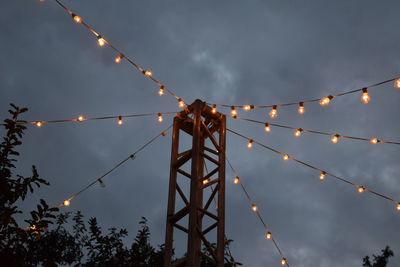 Low angle view of illuminated lights against sky at dusk