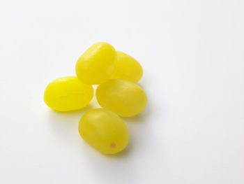 Close-up of yellow candies over white background