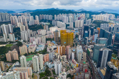 Aerial view of buildings in city against sky