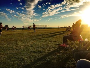 People on field against cloudy sky