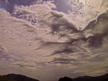 Scenic view of mountains against cloudy sky