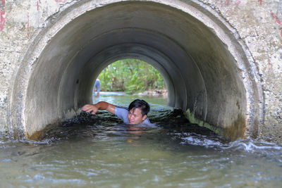 Portrait of man swimming in tunnel