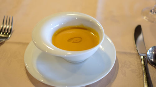 Close-up of tomato soup cup on table