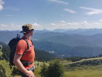 Side view of male hiker looking at mountains against sky