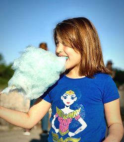 Close-up of happy girl holding blue outdoors