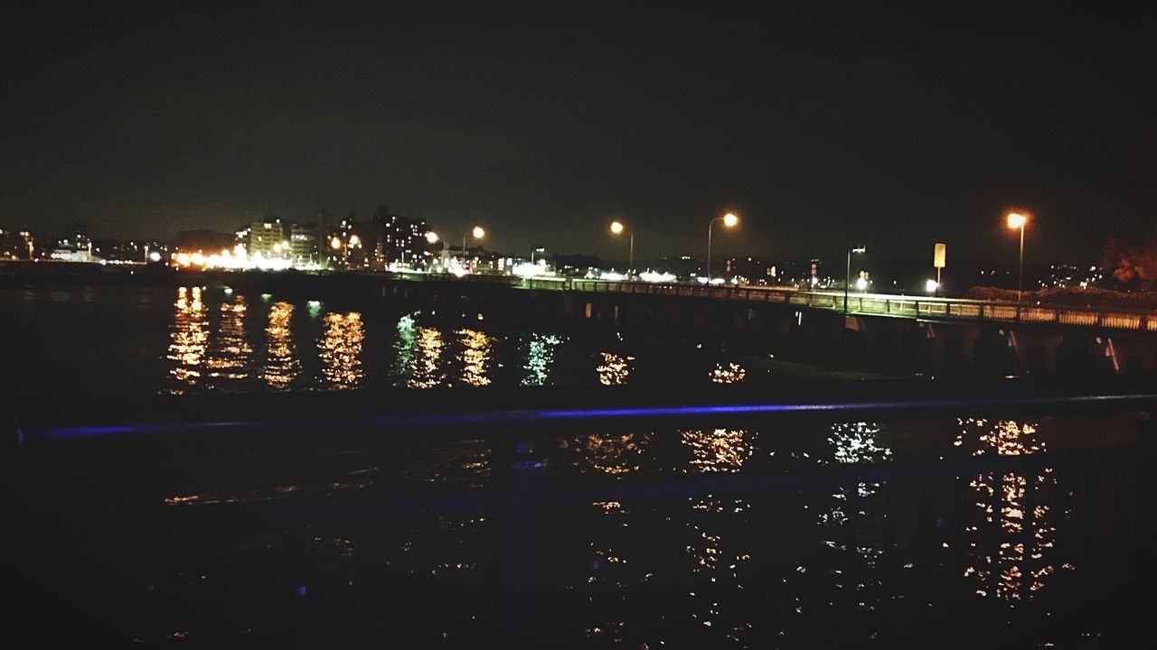 illuminated, night, water, river, reflection, architecture, built structure, city, building exterior, clear sky, bridge - man made structure, lighting equipment, street light, waterfront, cityscape, connection, lake, copy space, railing, dark