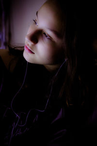 Close-up of thoughtful girl listening music while sitting at home