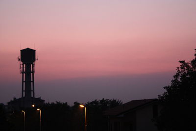 Silhouette water tower against sky at dusk