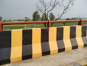 Striped crash barrier against sky 